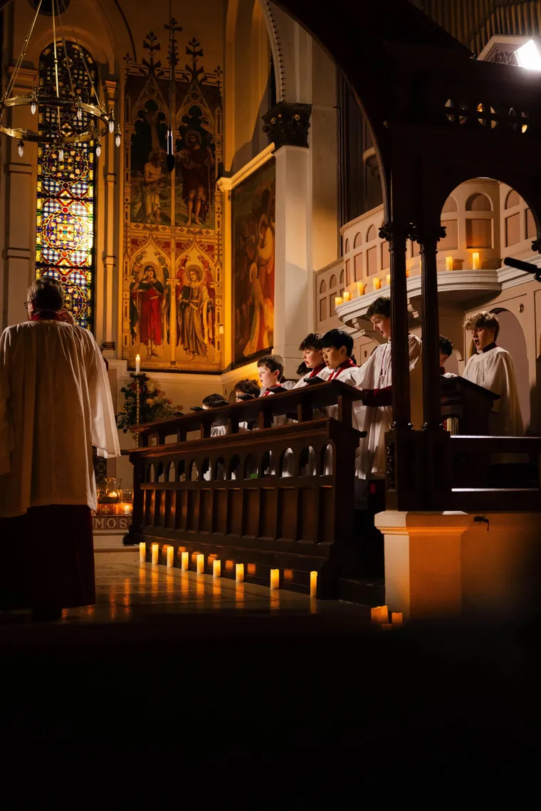 The Parish Choir of St George’s processing in red cassocks by candlelight
